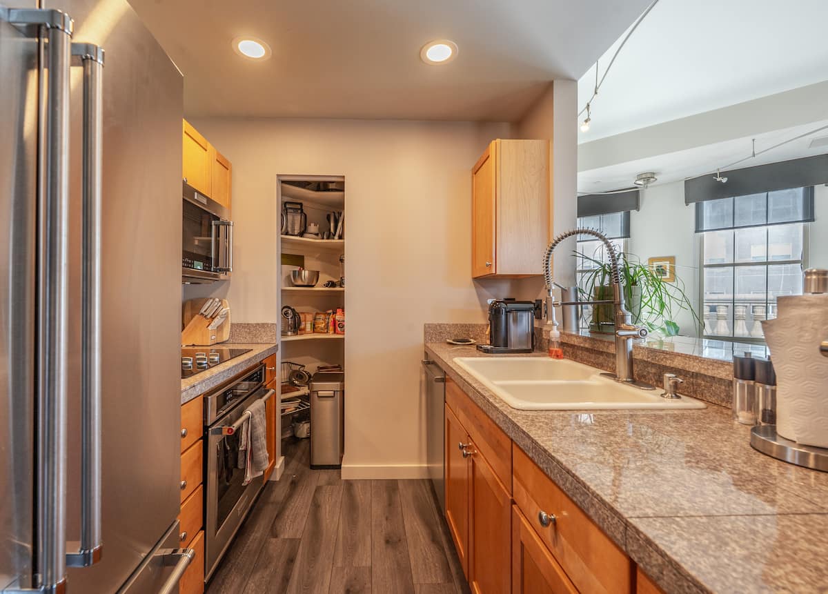 Galley kitchen with stainless appliances and a walk-in pantry