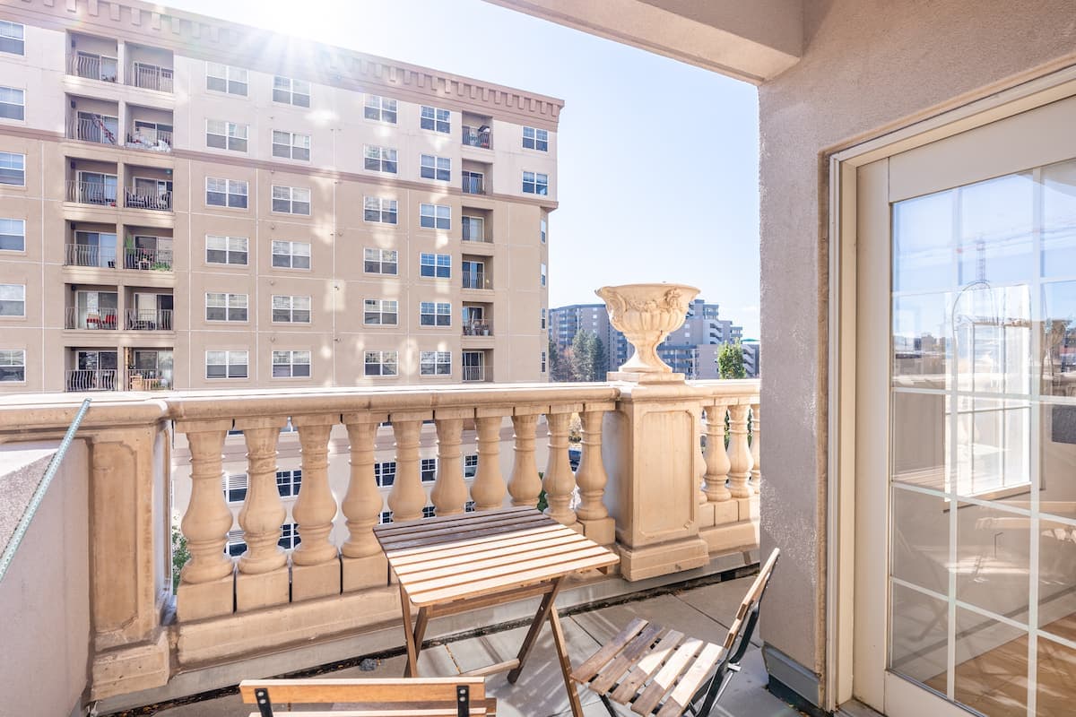 Private balcony with a bistro table behind a stone balustrade